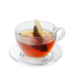 Putting tea bag into glass cup on white background