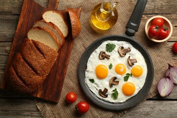 Tasty fried eggs with mushrooms and parsley served on wooden table, flat lay