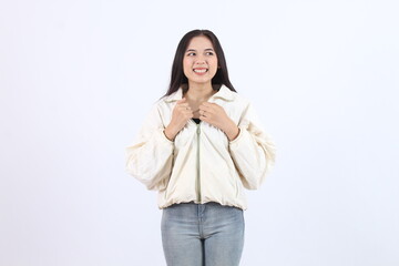 Asian girl feels hot and wants to take off her cream jacket to cool her body, because she is tired of the hot weather