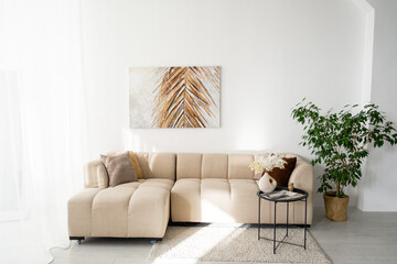 Modern living room with beige sectional and minimal decor in bright space