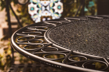An empty table on the terrace of a cafe, a wrought iron furniture, a cozy atmospheric photo on an...