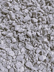 A close-up view of crushed gray stones, showcasing various sizes and shapes, often used in construction and landscaping.