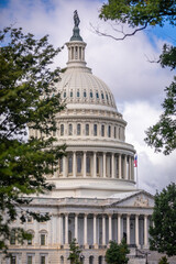US Capitol Building in Washington, DC - Partial View on a sunny Summer Day with blue Sky; Trees in...