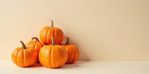 A vibrant autumnal still life featuring a charming arrangement of miniature pumpkins against a muted beige backdrop.