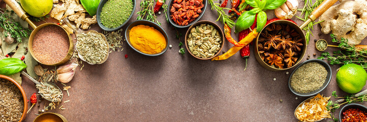 A visually striking arrangement of fresh spices and herbs on a brown surface, highlighting their vivid colors, intricate details, and rich culinary essence, banner