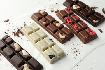 Tasty chocolate bars and crumbs on white background, closeup
