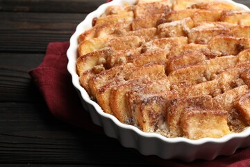Delicious bread pudding with raisins and cinnamon on wooden table, closeup