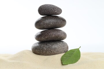 Stack of rocks on sand against white background. Harmony and life balance