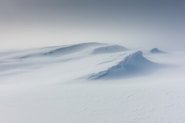 A blizzard covering a mountain pass, with snowdrifts burying the road and limiting visibility.