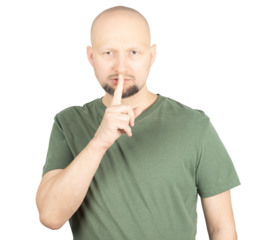 Serious man making a silence gesture by placing finger on lips
