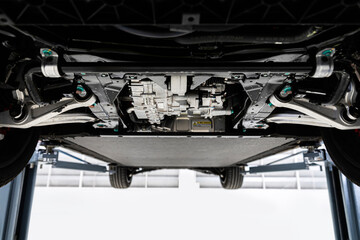 car at a service station on an electric lift , Bottom view of Electric car.