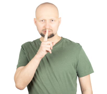 Serious man making a silence gesture by placing finger on lips