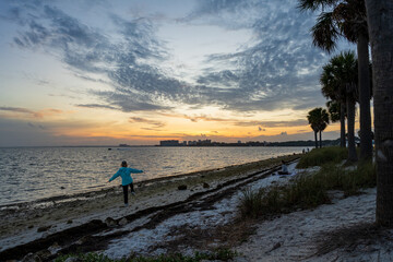 Photograph of a harbour during sunset with a city in the distance