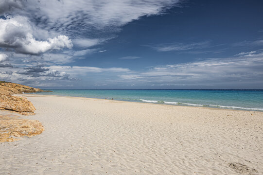 The beautiful beach of Pinus with fine sand and blue and turquoise water and storm clouds on the horizon