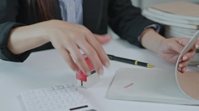Close up of hand use stamp of approval on document paperwork.