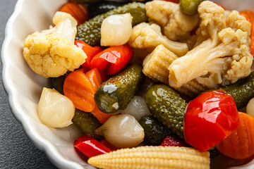 Marinated vegetables mix salad cucumber, corn, pepper, carrot, cauliflower, onion fresh tasty food dish gourmet food background on the table rustic food top view copy space vegetarian and vegan food