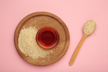 Sesame seeds and sesame oil isolated on pink background