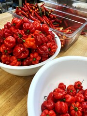 Scotch Bonnet chilli peppers and other red chillies being prepared in a kitchen