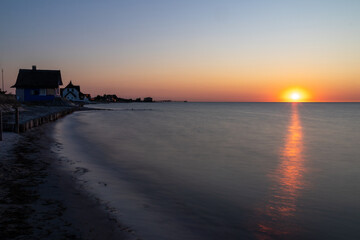 Blick von den Strandh&auml;usern in Heiligenhafen auf die Ostsee im Sonnenuntergang