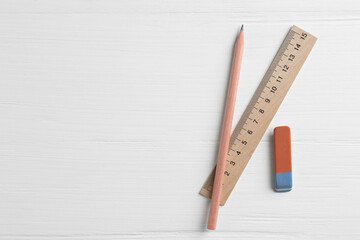 Ruler, pencil and eraser on white wooden table, flat lay. Space for text