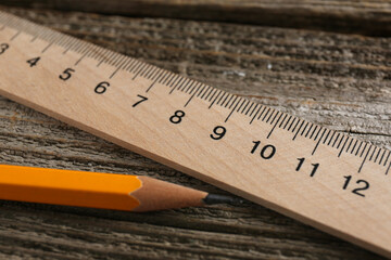 Ruler and pencil on wooden table, closeup