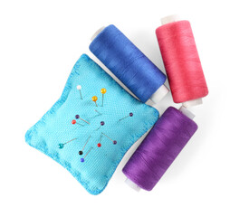 Pins, cushion and spools of thread isolated on white, top view. Sewing supplies