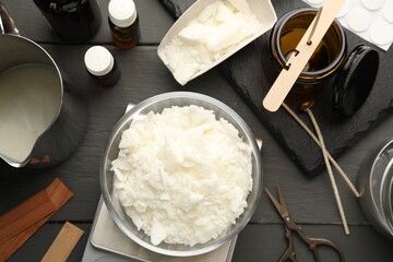 Soy wax, essential oils and different tools for making candles on grey wooden table, flat lay