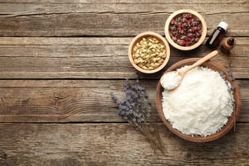 Soy wax in bowl and other different ingredients for making candles on wooden table, flat lay. Space for text
