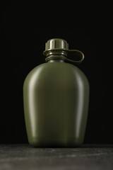 One green plastic canteen on black table