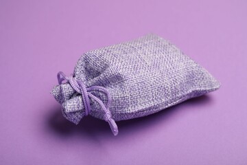 One burlap sack on violet background, closeup