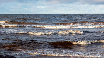 landscape with the seashore, windy winter day, water splashes, icy stones on the seashore, Baltic...