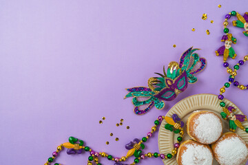Carnival or mardi gras concept with carnival masks, polish donuts and party decorations on purple background © maglara