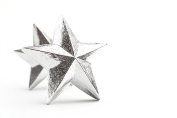 Obraz premium A pair of silver stars shining bright on a white surface, suitable for use in astronomy or design projects