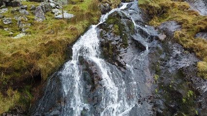 Aerial view of small waterfall cascading down Moel Druman mountain in Moelwyn mountains