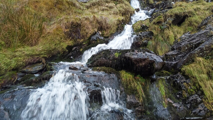 Aerial view of small waterfall cascading down Moel Druman mountain in Moelwyn mountains
