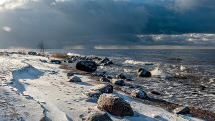 landscape with the seashore, windy winter day, water splashes, icy stones on the seashore, Baltic...