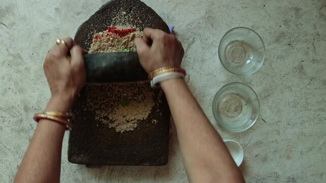 making paste of poppy seeds by mortar and pestle