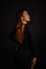 A portrait of a beautiful Asian woman in an open black dress, with red lipstick on her lips, exuding elegance, confidence, and timeless beauty