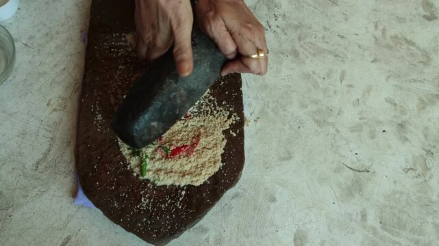 making paste of poppy seeds by mortar and pestle