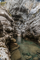 Arroyo con cascada con agua azul entre rocas de un desfiladero