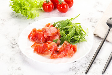 Sliced salmon with fresh arugula