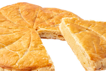 Paris, France - 01 24 2025: A homemade frangipani king cake with a slice of cake on a white background .