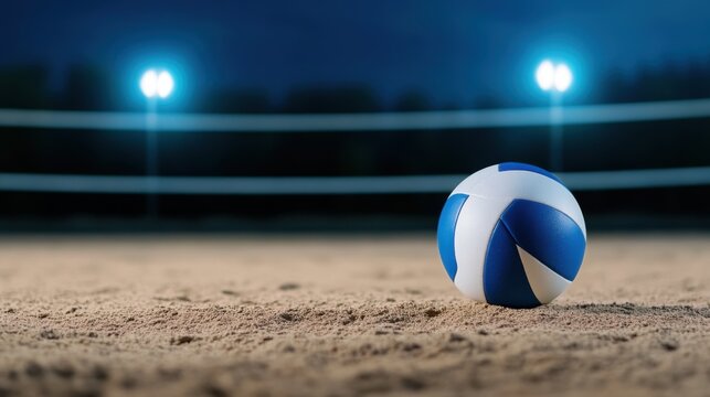 Blue and White Volleyball on Sandy Court with Night Lights Shining in Background at Beach Volleyball Venue