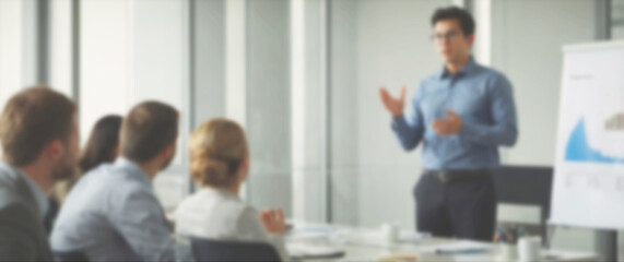 Blurred background of a group of professionals listening attentively to a presentation on business growth strategies, wide