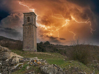 Church tower of haunted village Ochate with a firy thunderstorm and lightings in the sky, in Treviño, Burgos, Spain
