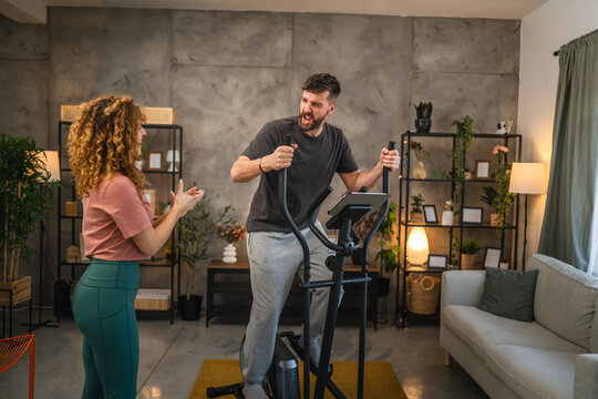 adult man exercise and use modern elliptical machine at home