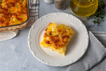 Potato gratin - graten (baked potatoes with cream and cheese) with rosemary and forks (Turkish name; Kremali patates)