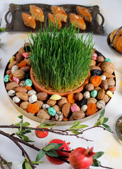 Traditional Azerbaijan holiday Novruz background with green semeni,traditional azerbaijan sweets,shekerbura,qogal,paxlava,mutaki and different nuts and sweets,top view,space for copy