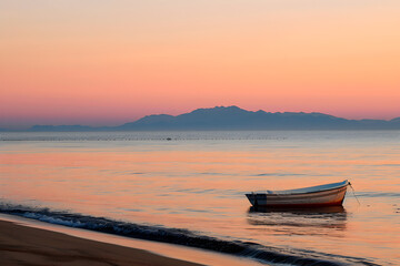 Naklejka premium Serene Beach Sunset: The Tranquil Dance of Waves and Sky at Dusk