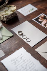 Wedding invitation set with rings and flowers on a rustic wood table..